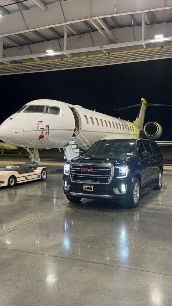 Luxury black SUV in front of a private jet — airport limo and black car service