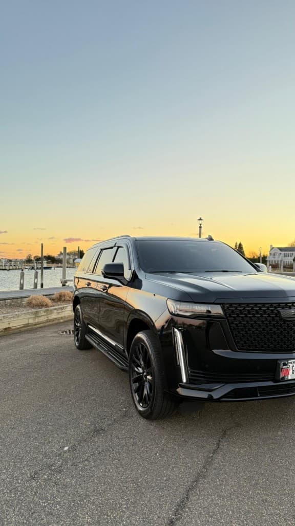 Black luxury Cadillac Escalade prom limo at sunset by the waterfront